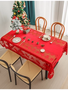 Detail of red Christmas lace tablecloth with reindeer and bell patterns for festive tables