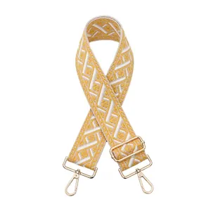 Detail of yellow and white geometric jacquard strap with gold metal lobster clasps