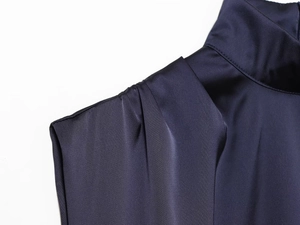 Détail du col montant et de l'épaule plissée sur la robe mini en satin bleu marine