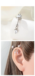 Macro detail of cupcake industrial barbell with heart zircon pendant on the ear