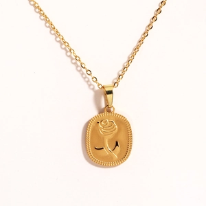 Close-up of golden oval pendant featuring embossed rose design on an O-shaped chain