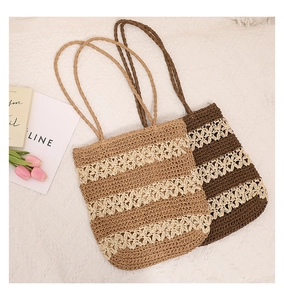 Detail of hollow-out woven straw tote bags with floral patterns for summer vacations