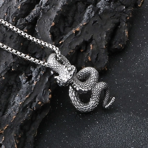 Detailed close-up of dark punk python snake pendant in vintage steel on rock background