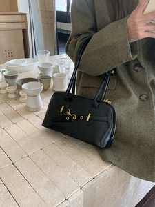 Classic black leather bowling bag with gold buckle and long handles for shoulder wear