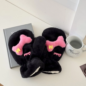 Detail of plush black mittens with pink bone decoration and soft white faux wool lining