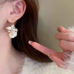 Gros plan de boucles d'oreilles papillon vintage avec cristaux et fleurs sur modèle