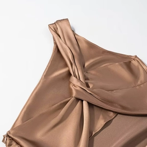 Detailed view of champagne satin dress with elegant knot shoulder and silky texture