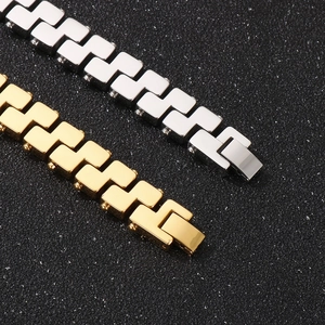Close-up of gold and silver geometric stainless steel link bracelets on black texture