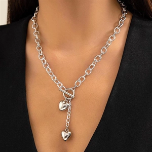 Detail of silver heart pendant necklace with toggle clasp on model neck