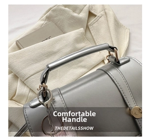 Détail de la poignée en cuir gris argenté du sac avec attaches métalliques rondes