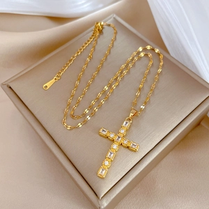 Elegant gold titanium steel necklace with a zircon-set cross pendant on beige silk