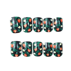 Short square press-on nails featuring red strawberry patterns on black glossy finish