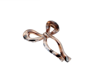 Detailed view of bow-shaped claw clip with brown tortoiseshell texture and metal spring