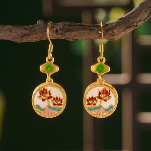 Macro shot of lotus enamel earrings hanging on a branch with traditional garden background
