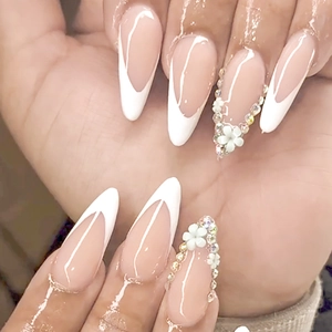 Elegant almond-shaped French press-on nails with white 3D flowers and tiny rhinestones