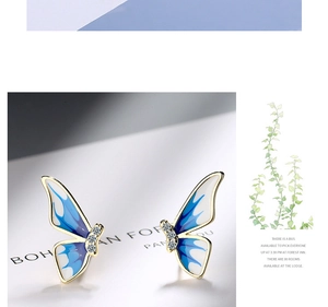Detail view of blue gradient enamel butterfly stud earrings with sparkling white zircons