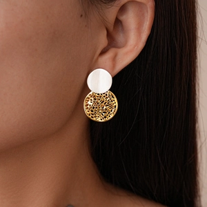 Close-up of geometric hollow round earrings with gold and silver two-tone plating on model