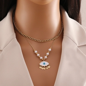 Double-layered gold chain necklace with white pearls and evil eye pendant for women