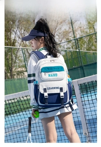 Outdoor shot of a color-block canvas backpack featuring durable flap buckle detail