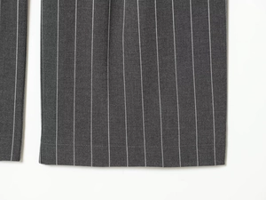Vue macro détaillée du pantalon de costume gris à rayures avec texture et couture de l'ourlet