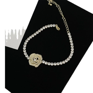 Elegant gold-tone star and camellia bracelet with white crystals on a vintage background