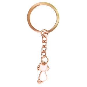 Detail of rose gold cat keychain with white enamel pendant on a clean white background