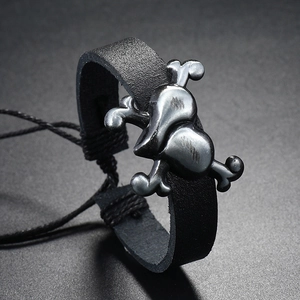 Detail of adjustable black woven leather bracelet with metal skull and crossbones motif