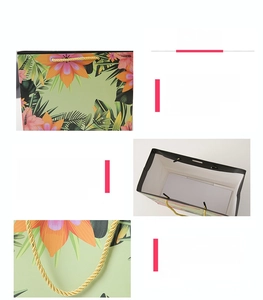 Detail of floral gift bag showing reinforced bottom and golden braided rope handles