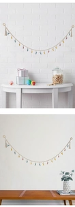 Detail of hand-woven beige cotton rope with colorful metal clips and tassel accents
