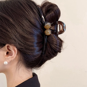 Brown tortoise shell acrylic claw clip with marble beads worn on hair from the back