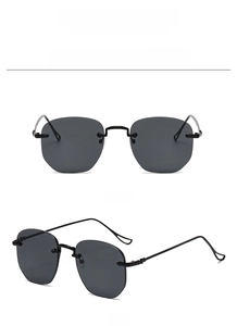 Detail view of black rimless sunglasses featuring sleek metal temples and clear nose pads