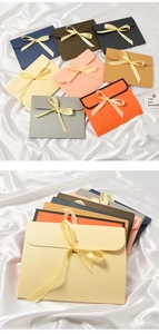 Detail of matte paper gift boxes in envelope style with elegant silk ribbon bow ties