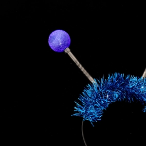 Close-up of blue alien headband with glowing spring balls on a black background