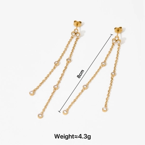 Detail of gold zircon tassel earrings, length 8cm, weighing 4.3g on white background