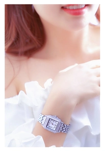 Detail of silver square watch with crystals, Roman numerals, and blue metallic hands