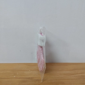 Close-up of a pink knitted Christmas stocking with white cuff in clear packaging