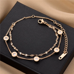 Close-up of a double-layer rose gold bracelet featuring Roman numeral rings and crystals