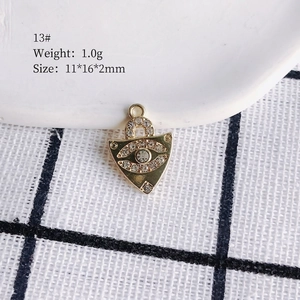 Detailed view of a golden evil eye pendant with white rhinestones, size 11x16x2mm