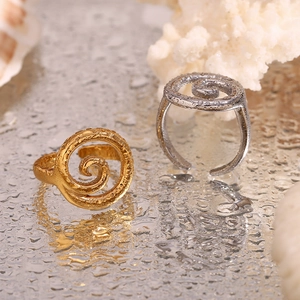 Detail showing gold and silver spiral rings with wavy texture on a water droplet surface