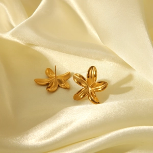 Détail de boucles d'oreilles tournesol en or 18 carats sur soie, design floral 3D