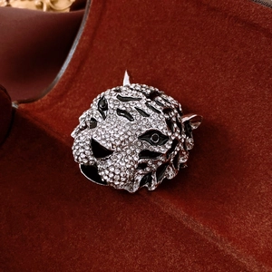 Close-up of vintage silver tiger head brooch with crystals and black enamel details