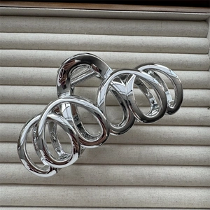 Macro detail of silver plated metal hair claw clip with spiral geometric design