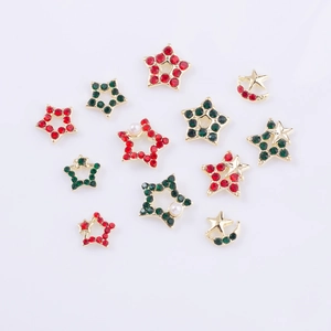 Détails de bijoux d'ongles de Noël avec strass rouges et verts sur des étoiles dorées