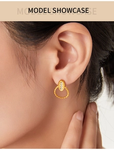Detail view of gold titanium earrings with twisted hoop and zircon on model