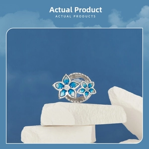Macro detail of S925 silver blue enamel flower bead with center sparkling white stone