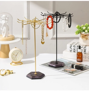 Détail du présentoir à bijoux avec 10 crochets dorés et noirs et base en marbre