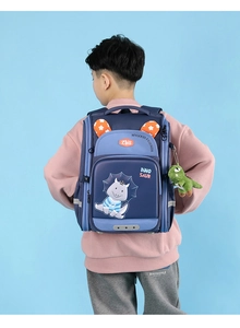 Blue dinosaur school bag for primary kids with cartoon patterns and hanging plush toy detail