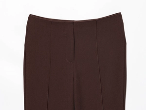 Detailed close-up of dark brown high-waisted trousers featuring precision stitching and seams