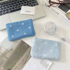 Detail of star-patterned denim mini pouches for cosmetics and coins on a desk