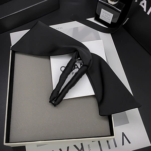 Elegante molletta a banana con grande fiocco in raso nero su sfondo di rivista moda